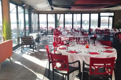 Foule dans une discothèque éclairée par des lumières bleues, avec une ambiance festive et un panneau lumineux au premier…