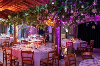 Miniature Location salle Gémenos (Bouches-du-Rhône) - Moulin de Gemenos #3 Salle de réception avec tables rondes dressées, nappes blanches, chaises en bois et décoration florale.