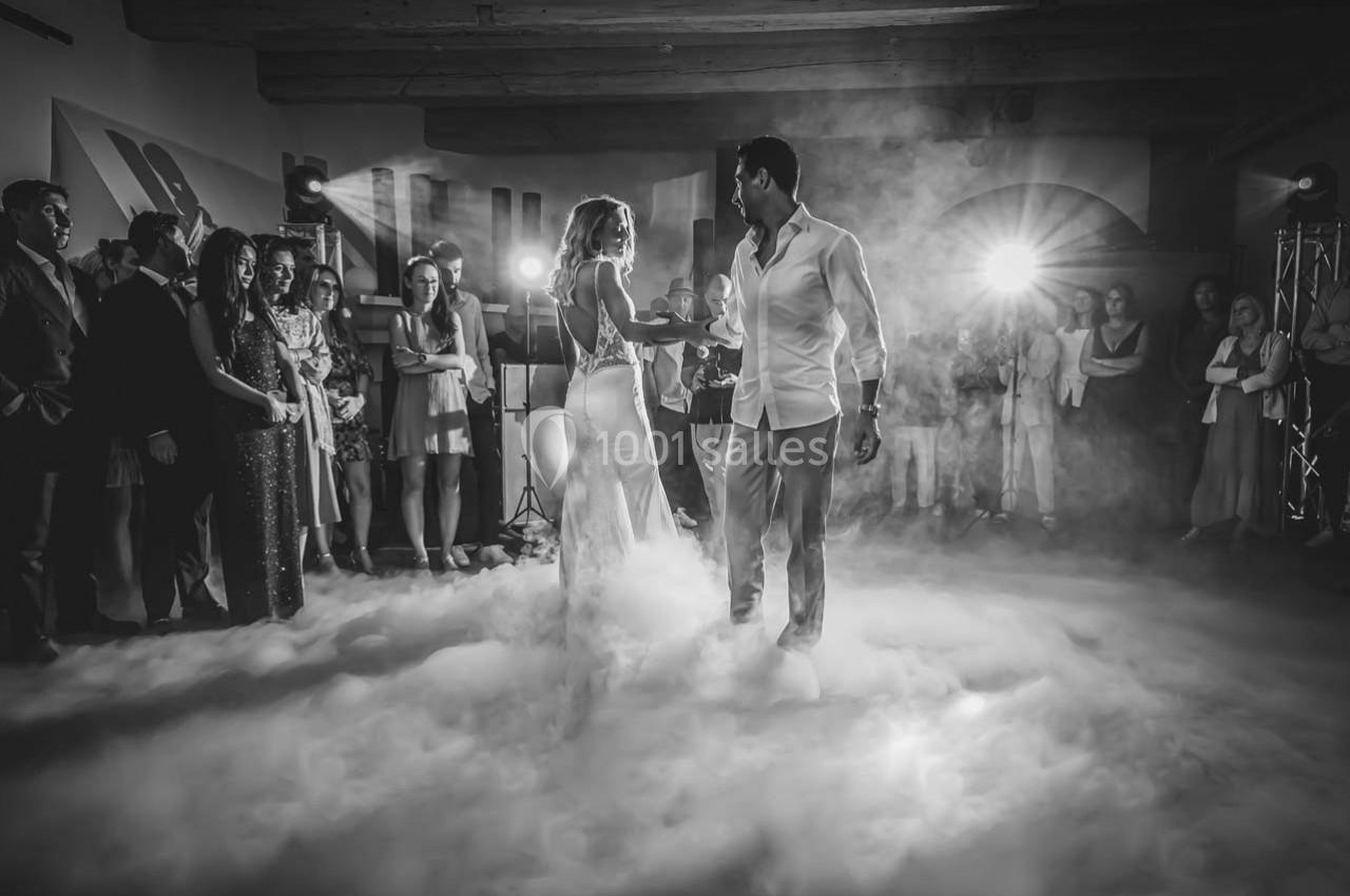 Location salle Gémenos (Bouches-du-Rhône) - Moulin de Gemenos #17 Un couple danse au milieu d'une piste enveloppée de fumée, entouré d'invités dans une ambiance festive.