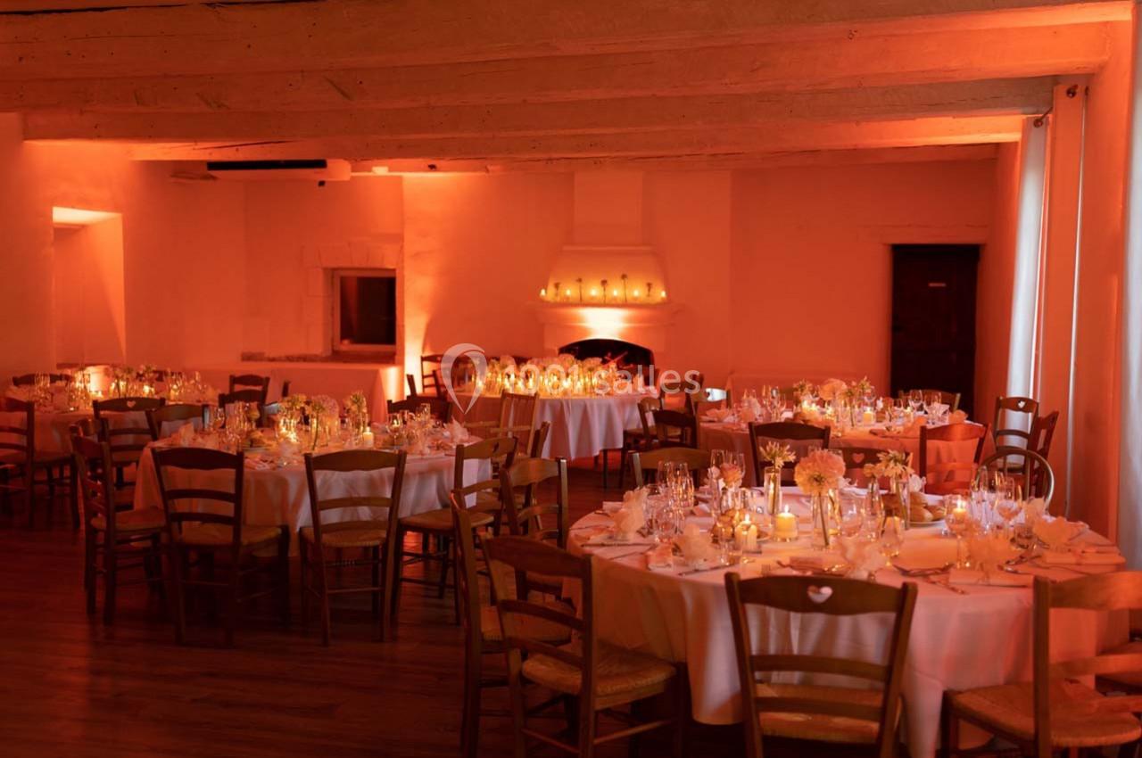 Location salle Gémenos (Bouches-du-Rhône) - Moulin de Gemenos #21 Salle de réception chaleureusement éclairée, avec des tables rondes dressées pour un dîner élégant.