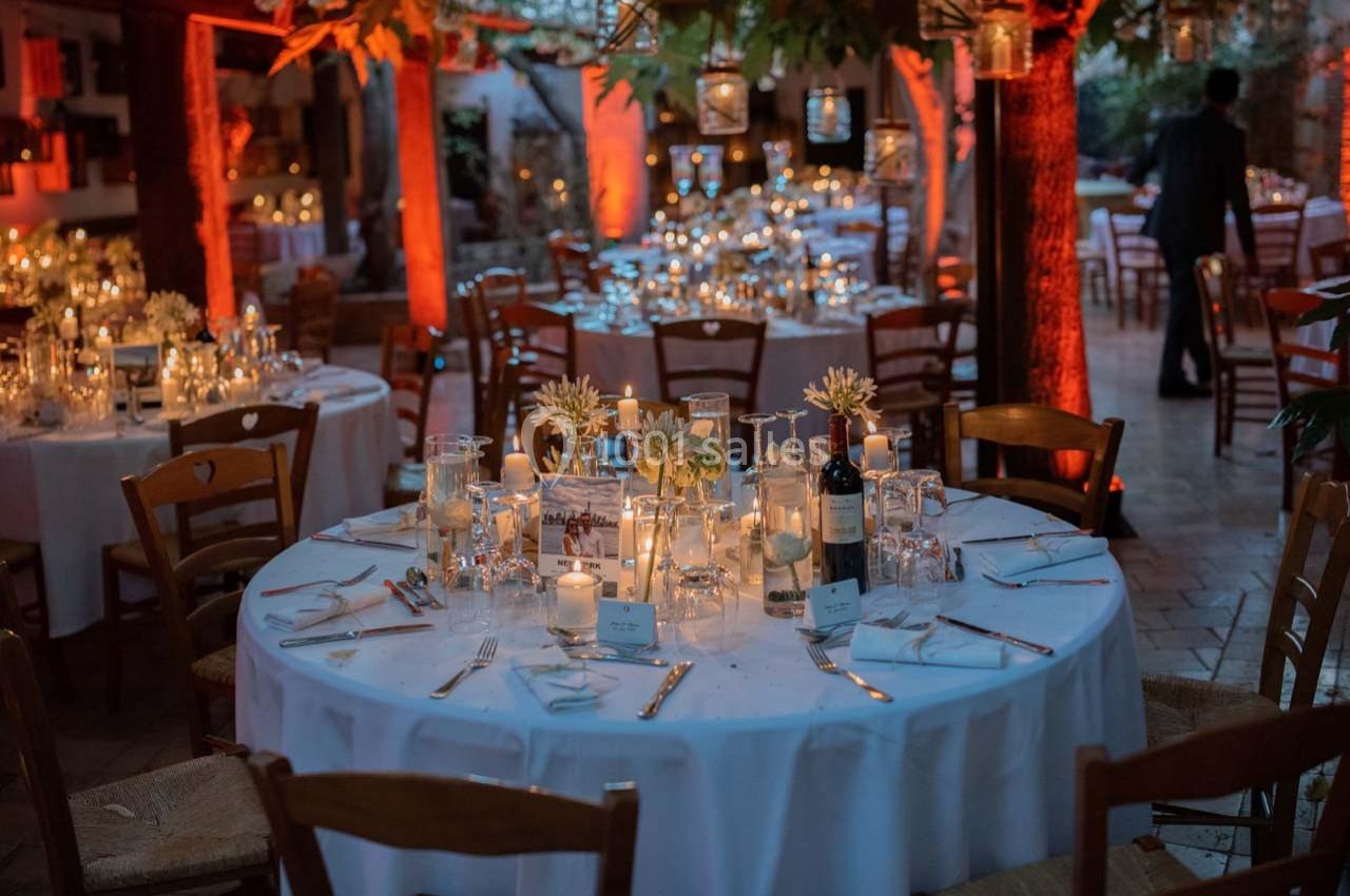 Location salle Gémenos (Bouches-du-Rhône) - Moulin de Gemenos #7 Salle décorée pour un dîner, avec tables rondes dressées, bougies allumées et éclairage chaleureux.