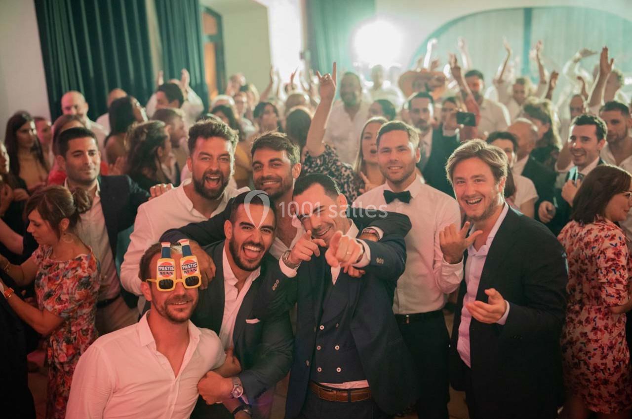 Location salle Gémenos (Bouches-du-Rhône) - Moulin de Gemenos #23 Un groupe de personnes souriantes posant lors d'une fête animée, entouré d'une foule festive en arrière-plan.