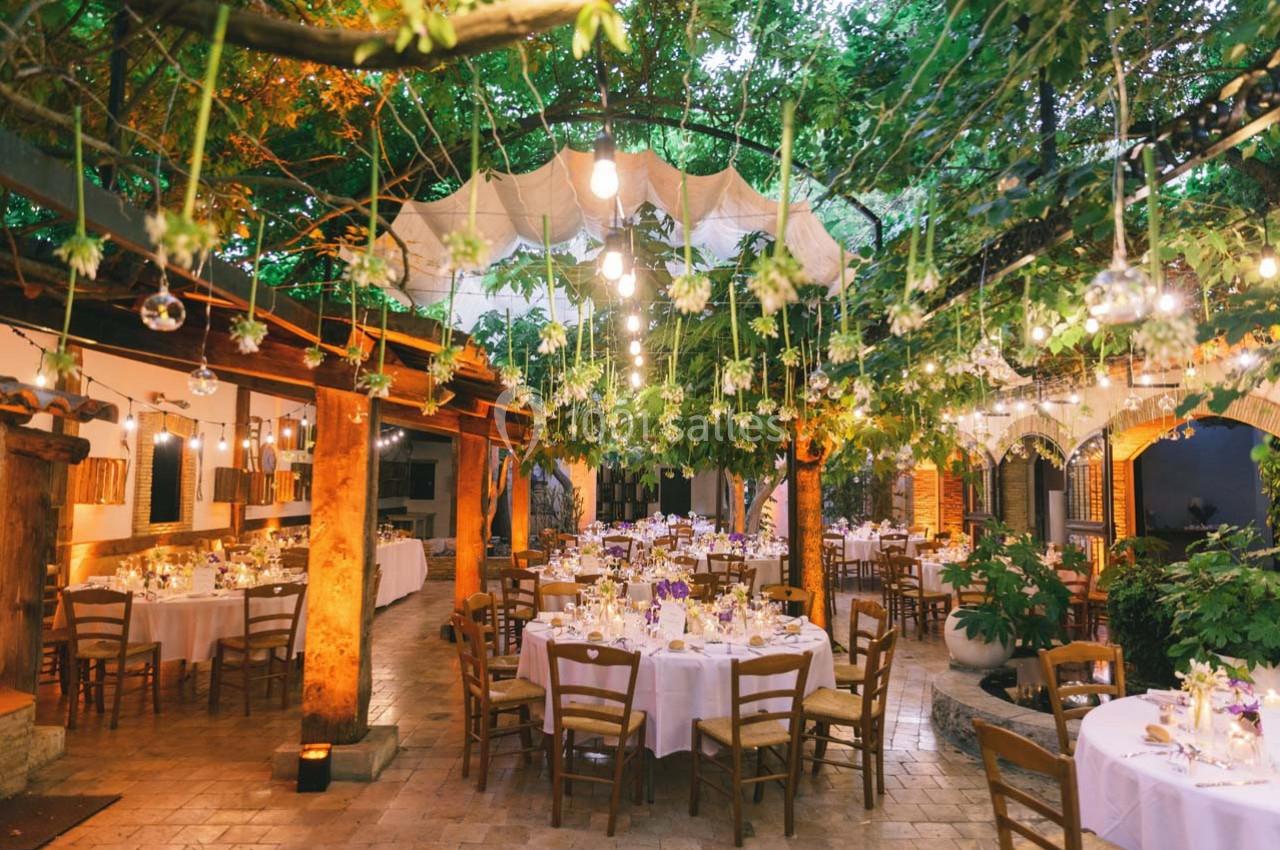 Location salle Gémenos (Bouches-du-Rhône) - Moulin de Gemenos #10 Salle de réception en plein air décorée de guirlandes lumineuses et de tables rondes dressées sous des arbres.