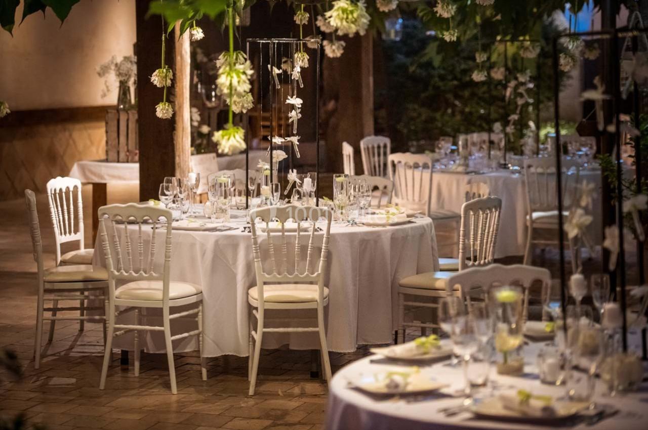 Location salle Gémenos (Bouches-du-Rhône) - Moulin de Gemenos #24 Salle de réception décorée avec des tables rondes, nappes blanches, chaises élégantes et éclairage tamisé.