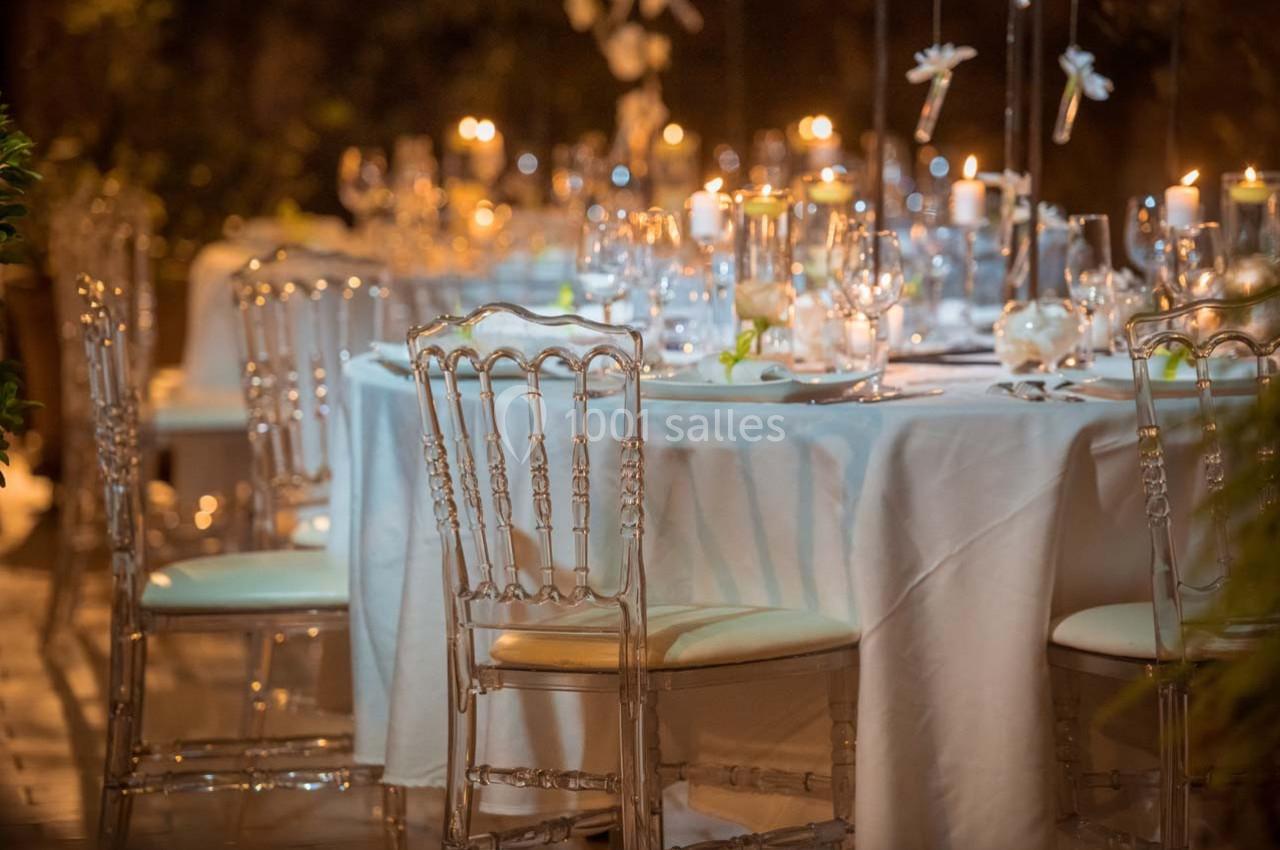 Location salle Gémenos (Bouches-du-Rhône) - Moulin de Gemenos #26 Table élégamment dressée avec nappes blanches, chaises transparentes et bougies allumées dans une ambiance tamisée.