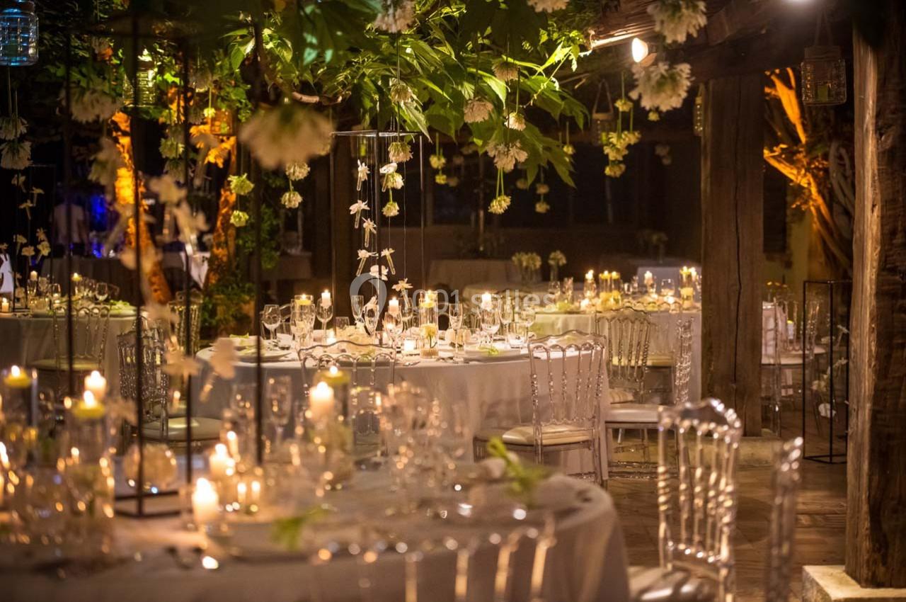 Location salle Gémenos (Bouches-du-Rhône) - Moulin de Gemenos #27 Salle de réception décorée de guirlandes lumineuses, bougies et fleurs suspendues, avec tables élégamment dressées.