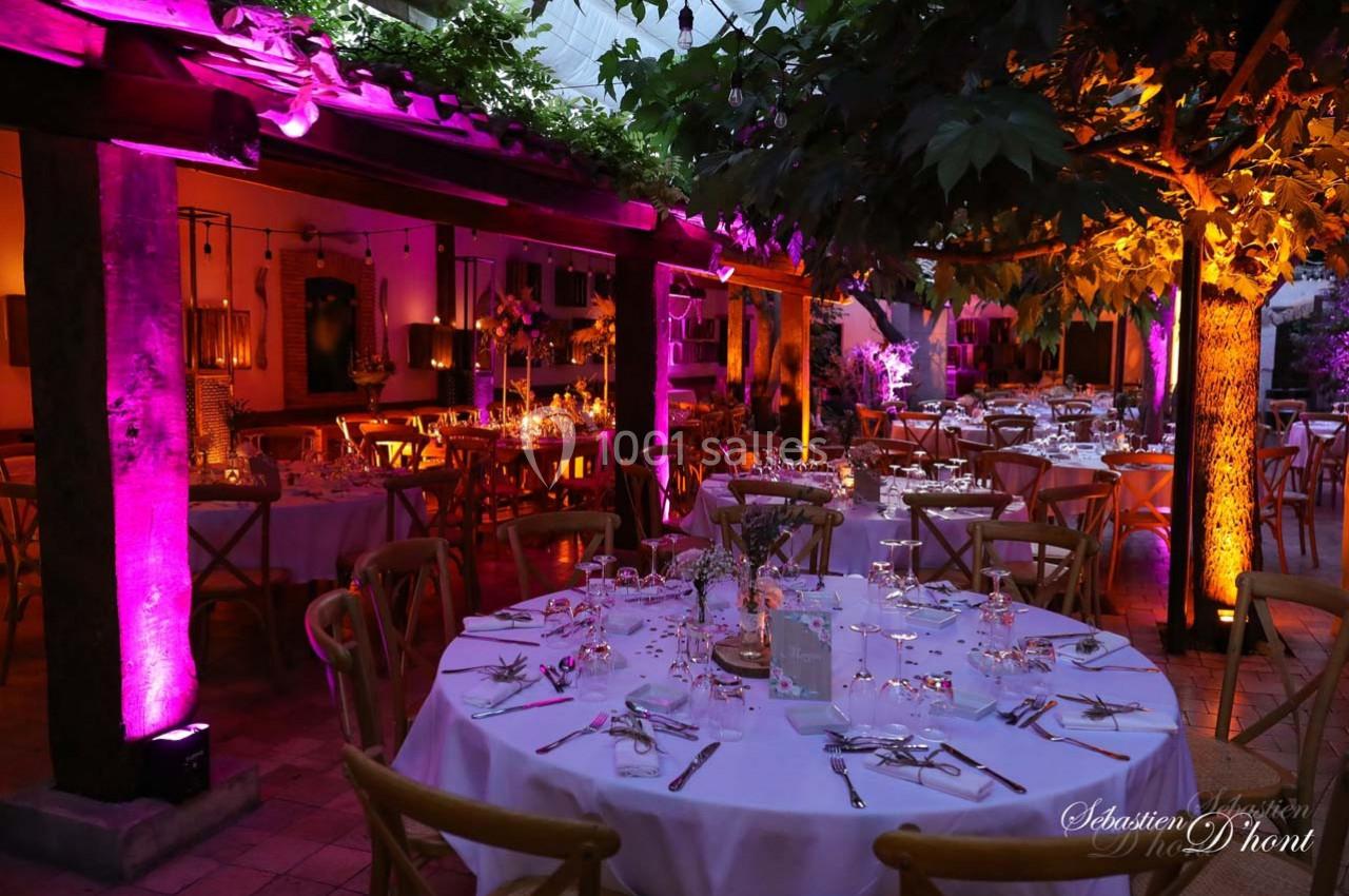 Location salle Gémenos (Bouches-du-Rhône) - Moulin de Gemenos #59 Salle de réception décorée avec des tables rondes dressées, éclairage coloré et ambiance chaleureuse en soirée.