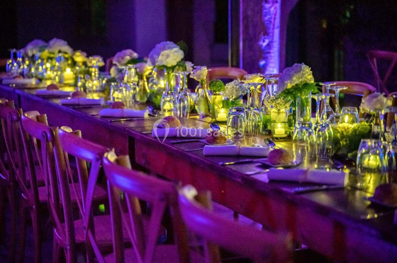 Location salle Gémenos (Bouches-du-Rhône) - Moulin de Gemenos #62 Table décorée avec des fleurs, bougies et vaisselle élégante, éclairée par une lumière tamisée dans une ambiance festive.