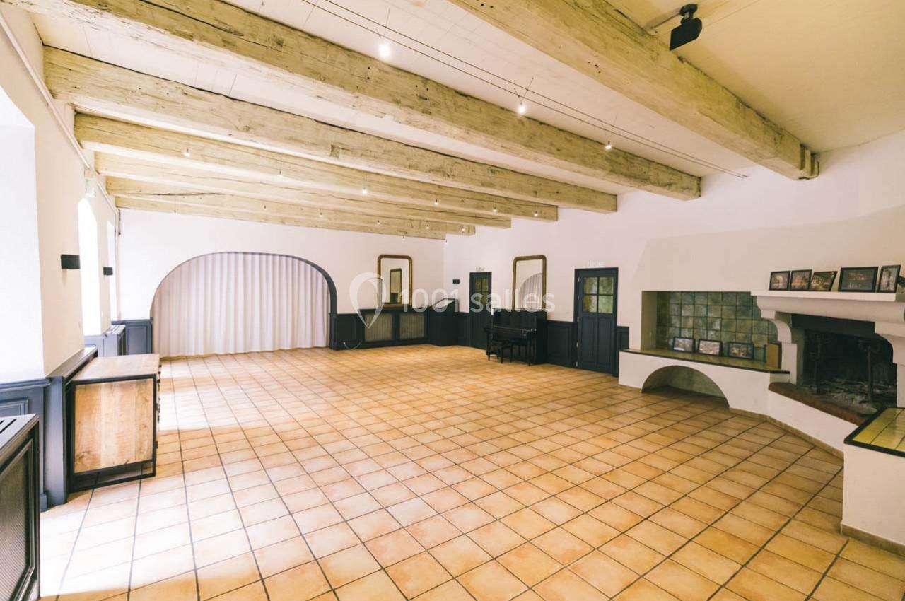 Location salle Gémenos (Bouches-du-Rhône) - Moulin de Gemenos #71 Salle lumineuse avec poutres apparentes, carrelage au sol, cheminée et mobilier en bois sombre.