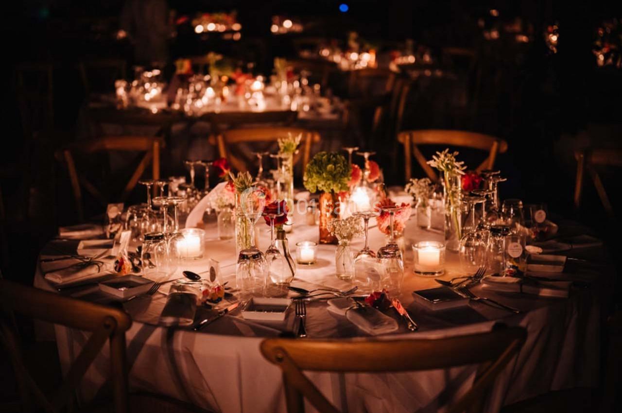 Location salle Gémenos (Bouches-du-Rhône) - Moulin de Gemenos #90 Table élégamment dressée avec des bougies allumées, des fleurs et des verres, dans une ambiance tamisée.