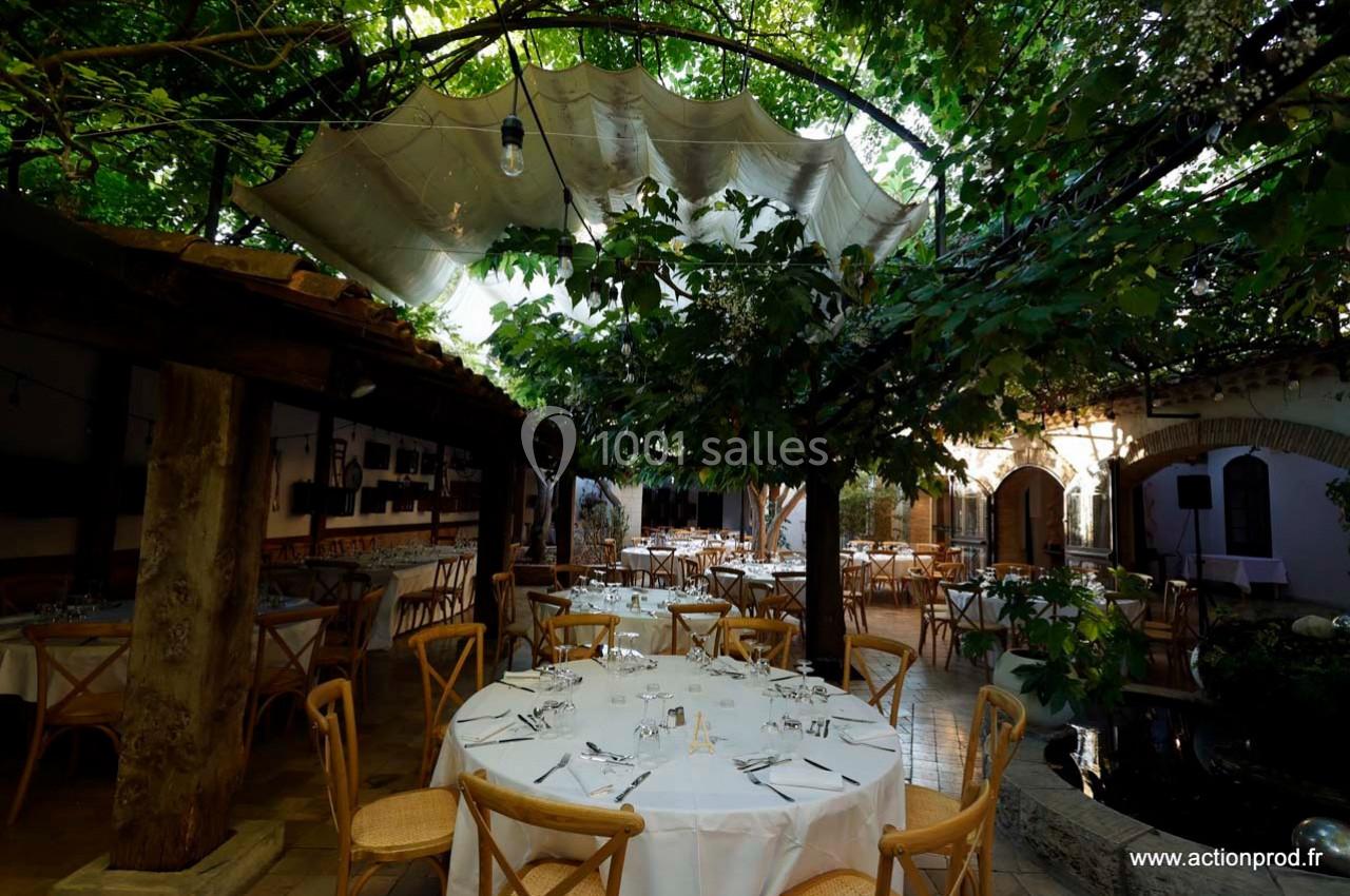 Location salle Gémenos (Bouches-du-Rhône) - Moulin de Gemenos #95 Salle de réception extérieure avec tables dressées sous une pergola ombragée par des arbres et une toile tendue.