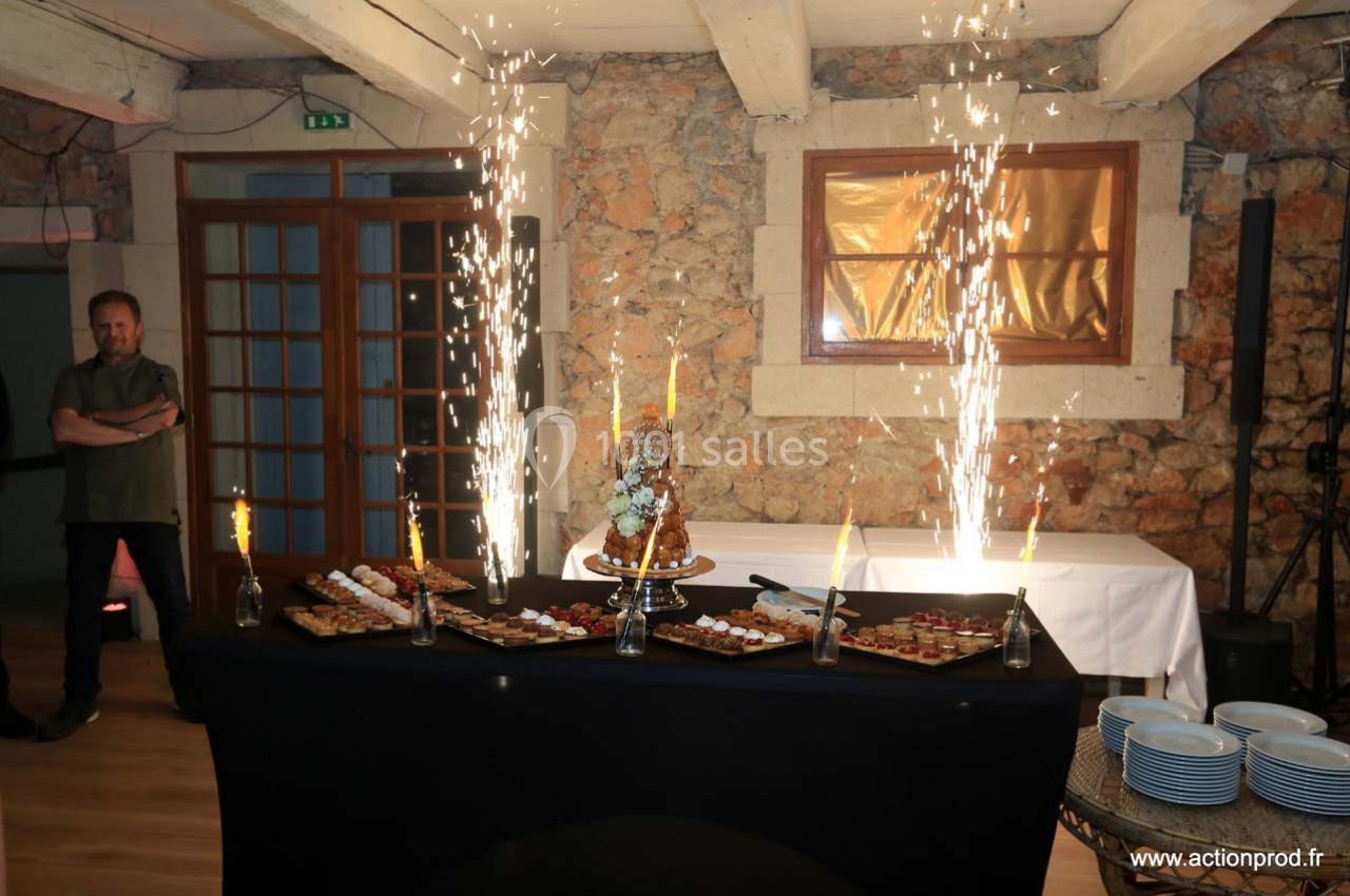 Location salle Gémenos (Bouches-du-Rhône) - Moulin de Gemenos #96 Table de desserts avec un croquembouche central, entourée de fontaines lumineuses dans une salle en pierre.