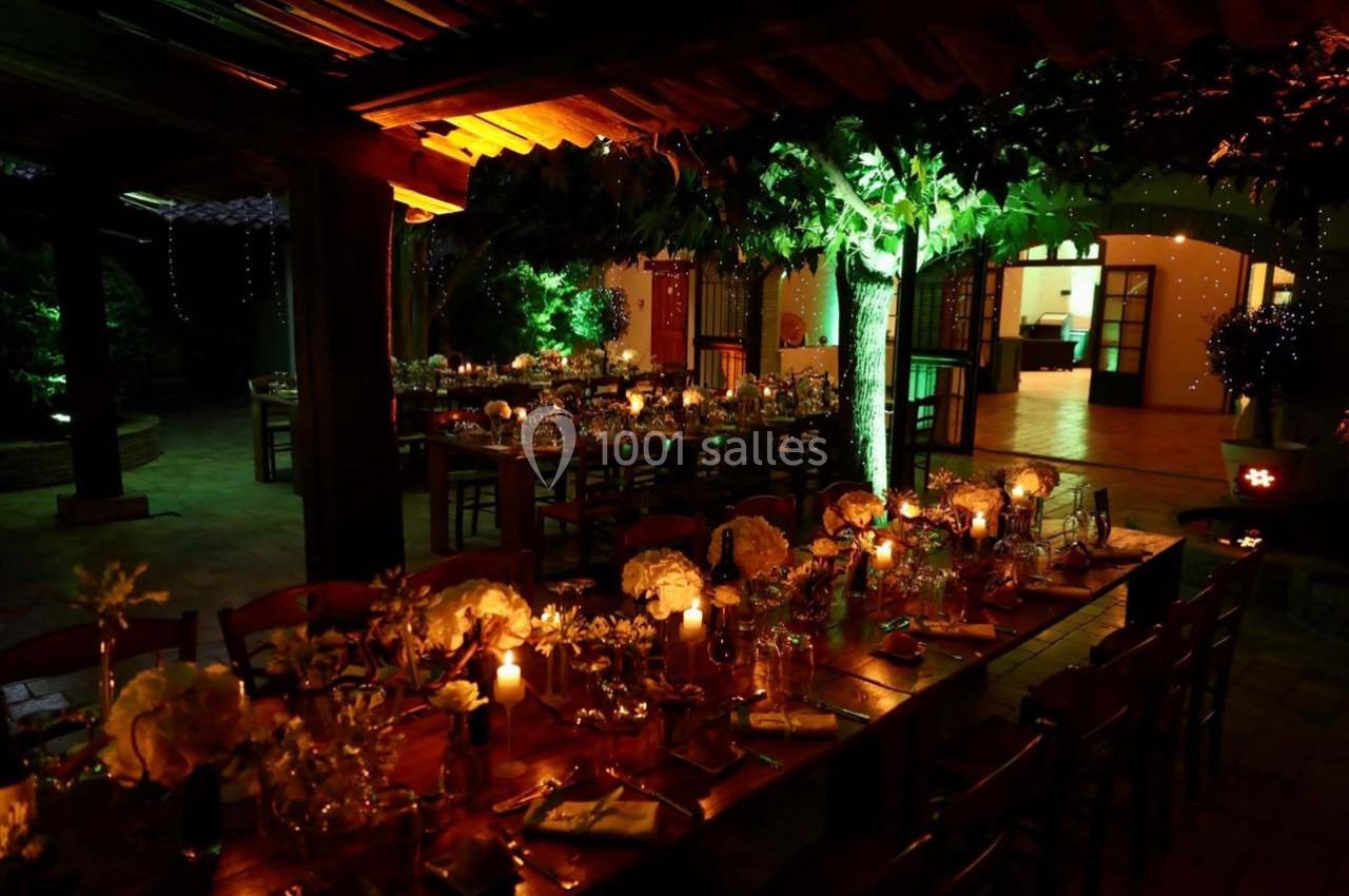 Location salle Gémenos (Bouches-du-Rhône) - Moulin de Gemenos #98 Salle de réception en soirée, éclairée par des lumières chaudes et décorée de tables dressées avec des fleurs et des bougies.