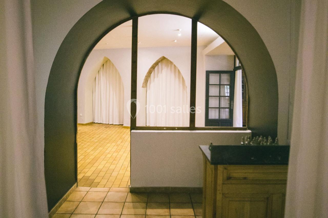 Location salle Gémenos (Bouches-du-Rhône) - Moulin de Gemenos #106 Vue d'un intérieur avec une arche, des rideaux blancs et un sol en carreaux de terre cuite.