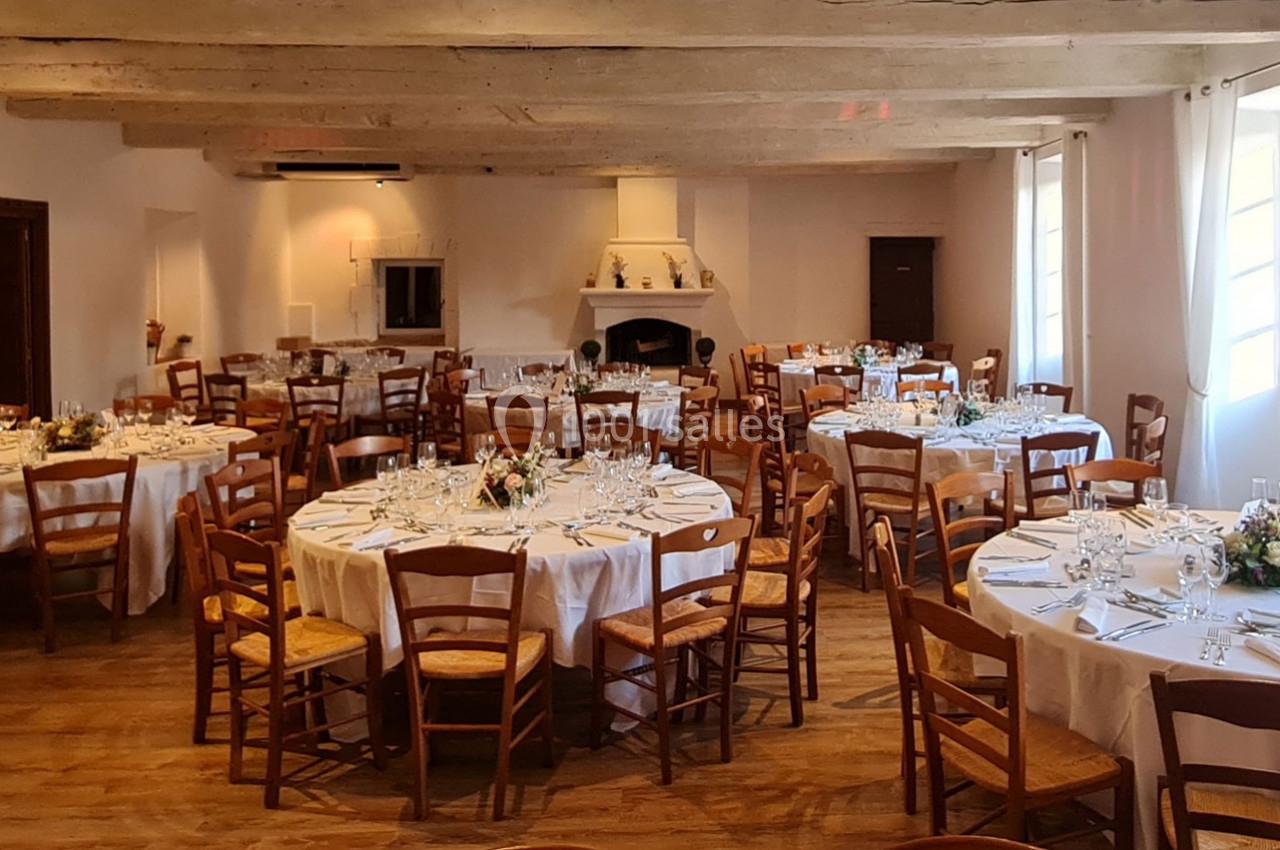 Location salle Gémenos (Bouches-du-Rhône) - Moulin de Gemenos #117 Salle de réception avec tables rondes dressées, nappes blanches, chaises en bois et décoration florale.