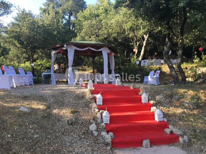 Location salle La Roquebrussanne (Var) - Les Arbousiers #20 Escalier extérieur recouvert d'un tapis rouge menant à une pergola décorée pour un événement en plein air.
