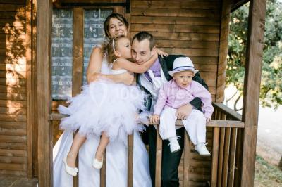 Miniature Location salle La Roquebrussanne (Var) - Les Arbousiers #34 Un couple en tenue de mariage coupe une pièce montée décorée, devant un mur en pierre.