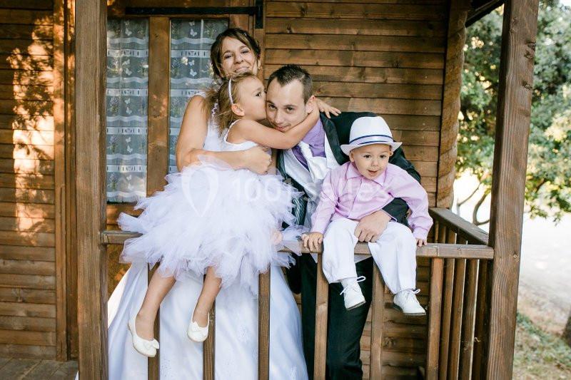 Location salle La Roquebrussanne (Var) - Les Arbousiers #34 Une famille souriante posant sur le balcon en bois d'une maison, avec deux enfants en tenue élégante.