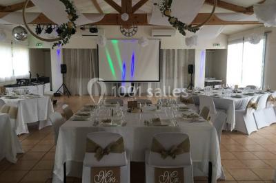 Miniature Location salle La Roquebrussanne (Var) - Les Arbousiers #29 Un couple en tenue de mariage coupe une pièce montée décorée, devant un mur en pierre.