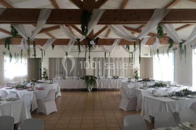 Miniature Location salle La Roquebrussanne (Var) - Les Arbousiers #18 Un couple en tenue de mariage coupe une pièce montée décorée, devant un mur en pierre.