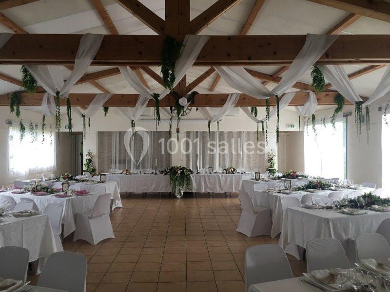 Location salle La Roquebrussanne (Var) - Les Arbousiers #18 Salle de réception décorée avec des nappes blanches, des guirlandes végétales suspendues et des tables dressées.