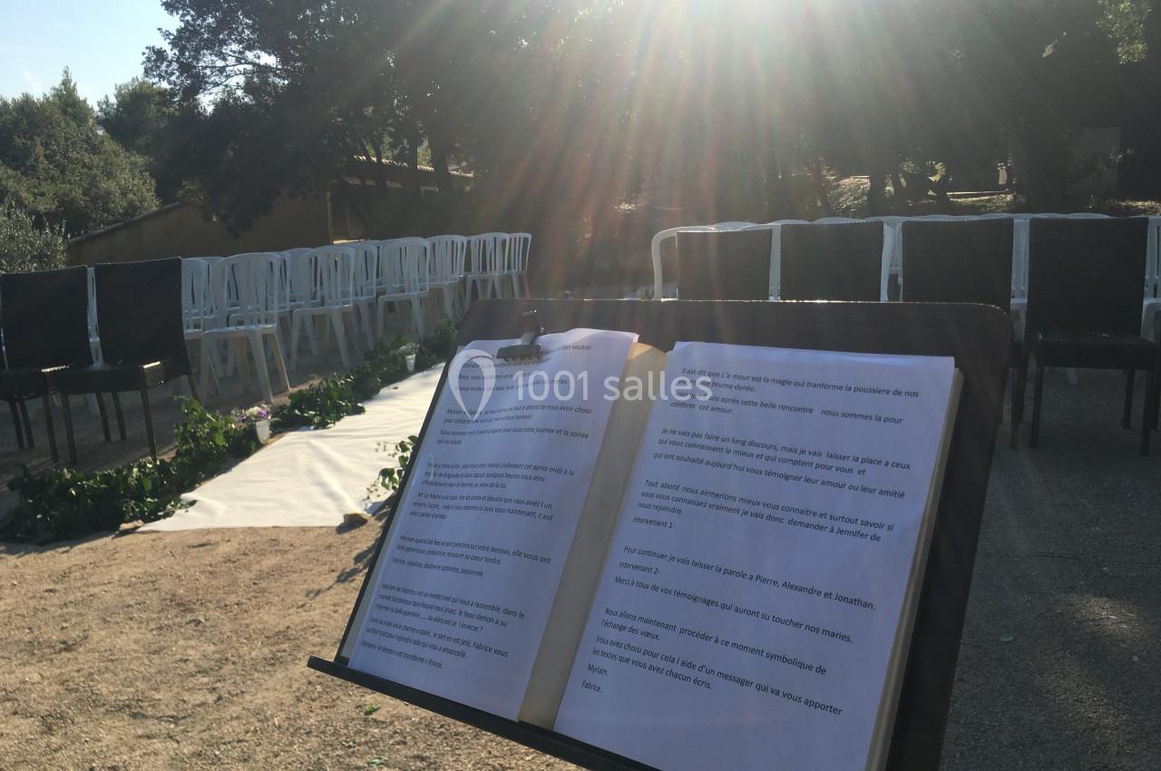 Location salle La Roquebrussanne (Var) - Les Arbousiers #26 Livre ouvert sur un pupitre en plein air, devant des chaises disposées pour un événement sous un soleil éclatant.