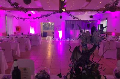 Miniature Location salle La Roquebrussanne (Var) - Les Arbousiers #38 Un couple en tenue de mariage coupe une pièce montée décorée, devant un mur en pierre.