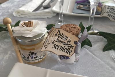 Miniature Location salle La Roquebrussanne (Var) - Les Arbousiers #39 Un couple en tenue de mariage coupe une pièce montée décorée, devant un mur en pierre.