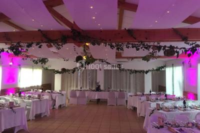 Miniature Location salle La Roquebrussanne (Var) - Les Arbousiers #19 Un couple en tenue de mariage coupe une pièce montée décorée, devant un mur en pierre.