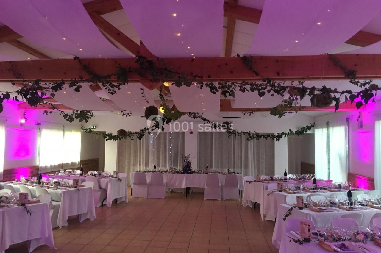 Location salle La Roquebrussanne (Var) - Les Arbousiers #19 Salle de réception décorée avec des guirlandes végétales, éclairage rose et tables dressées pour un événement.