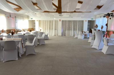 Miniature Location salle La Roquebrussanne (Var) - Les Arbousiers #5 Un couple en tenue de mariage coupe une pièce montée décorée, devant un mur en pierre.