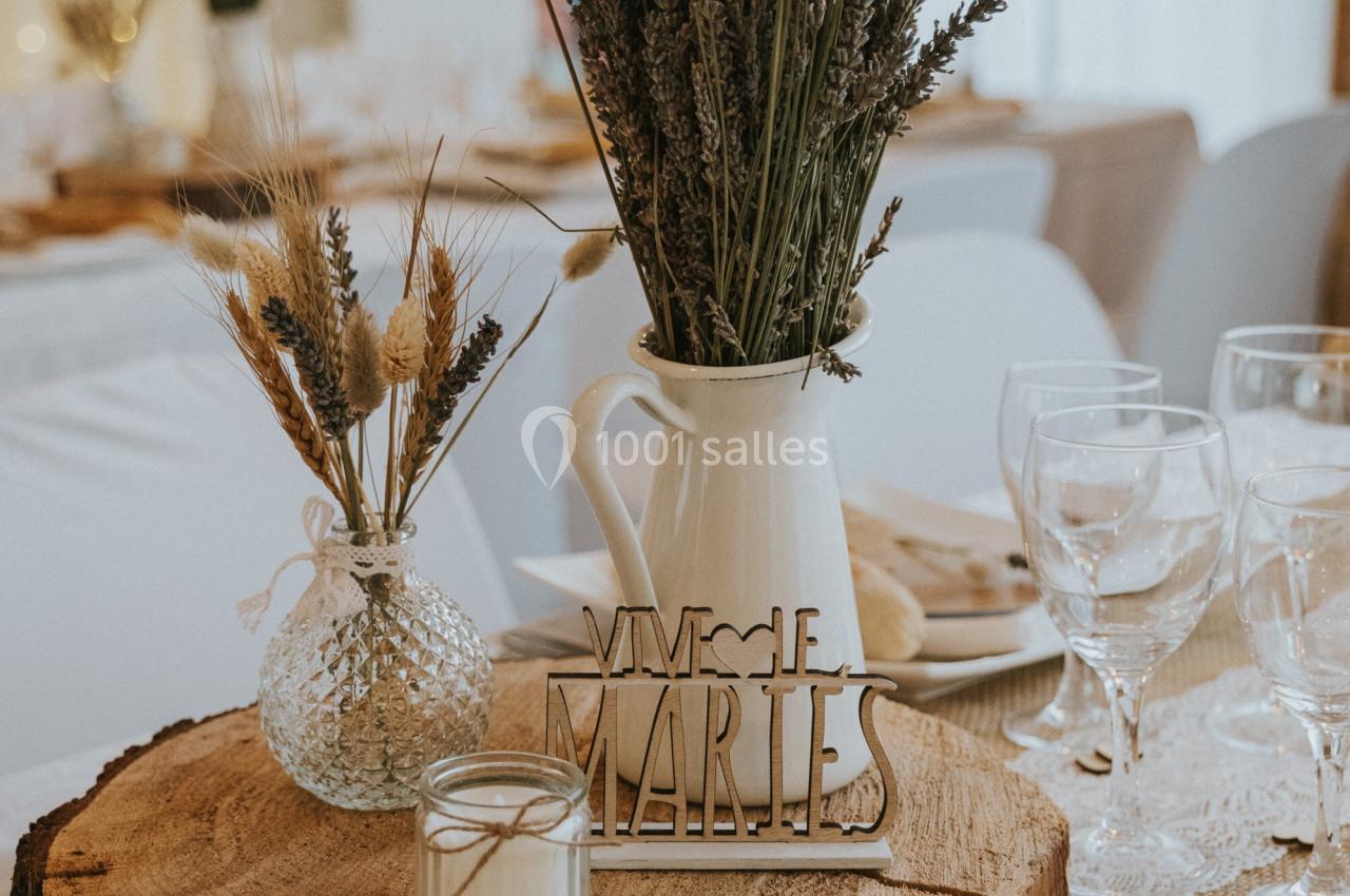 Location salle La Roquebrussanne (Var) - Les Arbousiers #41 Centre de table rustique avec rondin de bois, bouquet de lavande, bougie et décoration ’Vive les mariés’.