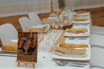 Miniature Location salle La Roquebrussanne (Var) - Les Arbousiers #42 Un couple en tenue de mariage coupe une pièce montée décorée, devant un mur en pierre.