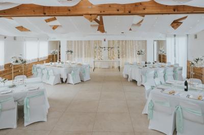 Miniature Location salle La Roquebrussanne (Var) - Les Arbousiers #3 Un couple en tenue de mariage coupe une pièce montée décorée, devant un mur en pierre.