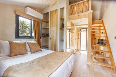 Table dressée avec assiettes en céramique, serviettes vertes pliées, couverts dorés, verres et décoration florale blanche.