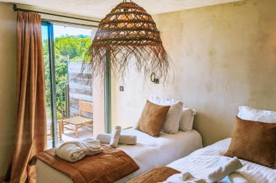 Table dressée avec assiettes en céramique, serviettes vertes pliées, couverts dorés, verres et décoration florale blanche.