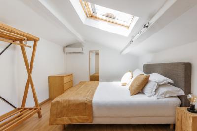 Table dressée avec assiettes en céramique, serviettes vertes pliées, couverts dorés, verres et décoration florale blanche.