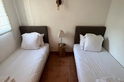 Table dressée avec assiettes en céramique, serviettes vertes pliées, couverts dorés, verres et décoration florale blanche.