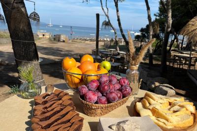 Table dressée avec assiettes en céramique, serviettes vertes pliées, couverts dorés, verres et décoration florale blanche.