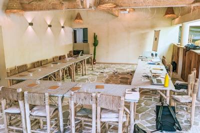 Table dressée avec assiettes en céramique, serviettes vertes pliées, couverts dorés, verres et décoration florale blanche.