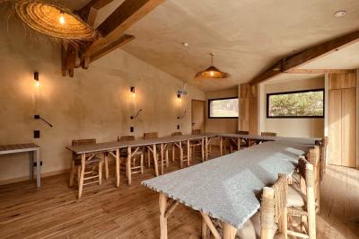 Table dressée avec assiettes en céramique, serviettes vertes pliées, couverts dorés, verres et décoration florale blanche.