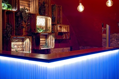 Miniature Location salle Paris 4 (Paris) - Paris Clandestin #20 Fléchettes colorées dans une caisse en bois au premier plan, cible de jeu accrochée sur un mur en pierre en arrière-plan.