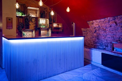 Miniature Location salle Paris 4 (Paris) - Paris Clandestin #22 Fléchettes colorées dans une caisse en bois au premier plan, cible de jeu accrochée sur un mur en pierre en arrière-plan.