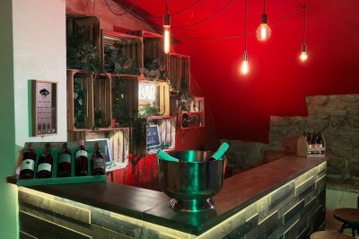 Miniature Location salle Paris 4 (Paris) - Paris Clandestin #28 Fléchettes colorées dans une caisse en bois au premier plan, cible de jeu accrochée sur un mur en pierre en arrière-plan.