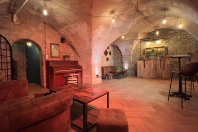 Miniature Location salle Paris 4 (Paris) - Paris Clandestin #3 Fléchettes colorées dans une caisse en bois au premier plan, cible de jeu accrochée sur un mur en pierre en arrière-plan.