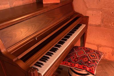 Miniature Le Pub Fléchettes colorées dans une caisse en bois au premier plan, cible de jeu accrochée sur un mur en pierre en arrière-plan.