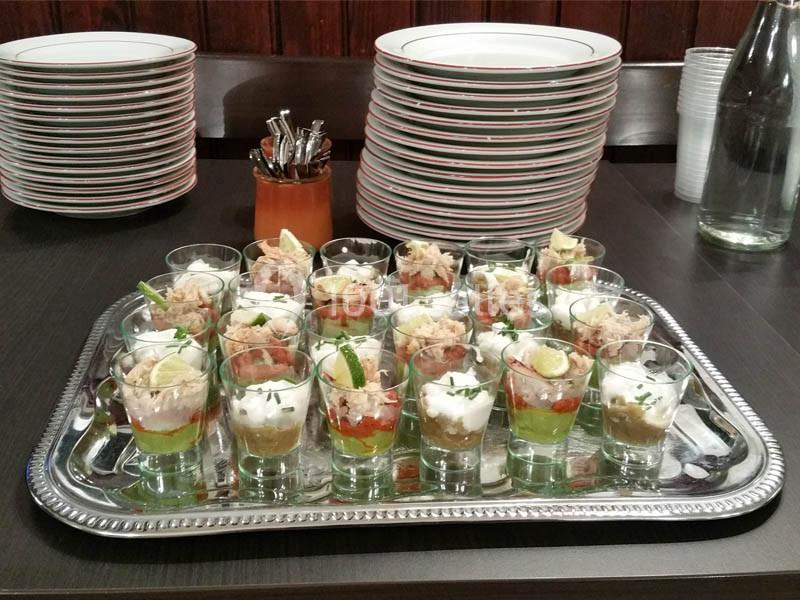 Location salle Bordeaux (Gironde) - Restaurant Le Family #23 Plateau de verrines variées avec des ingrédients colorés, disposé sur une table près d'assiettes empilées.