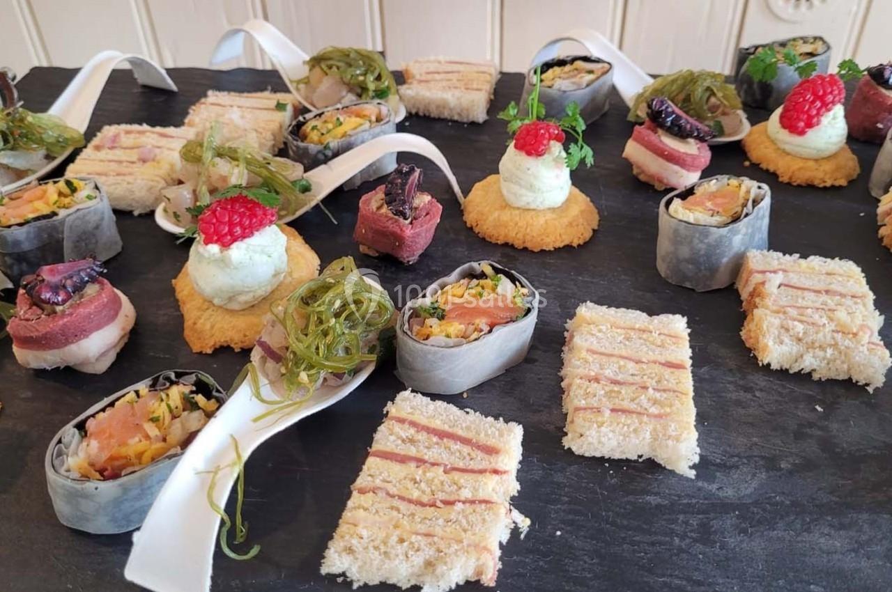 Location salle Bordeaux (Gironde) - Restaurant Le Family #36 Plateau de bouchées variées comprenant sushis, toasts, mousse et garnitures colorées sur une ardoise noire.