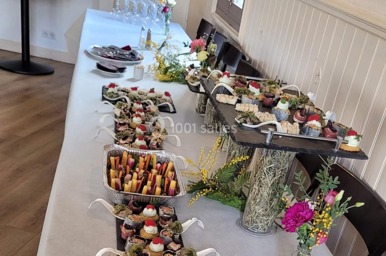 Location salle Bordeaux (Gironde) - Restaurant Le Family #15 Buffet de desserts variés et colorés disposés sur une table décorée de fleurs dans une salle lumineuse.