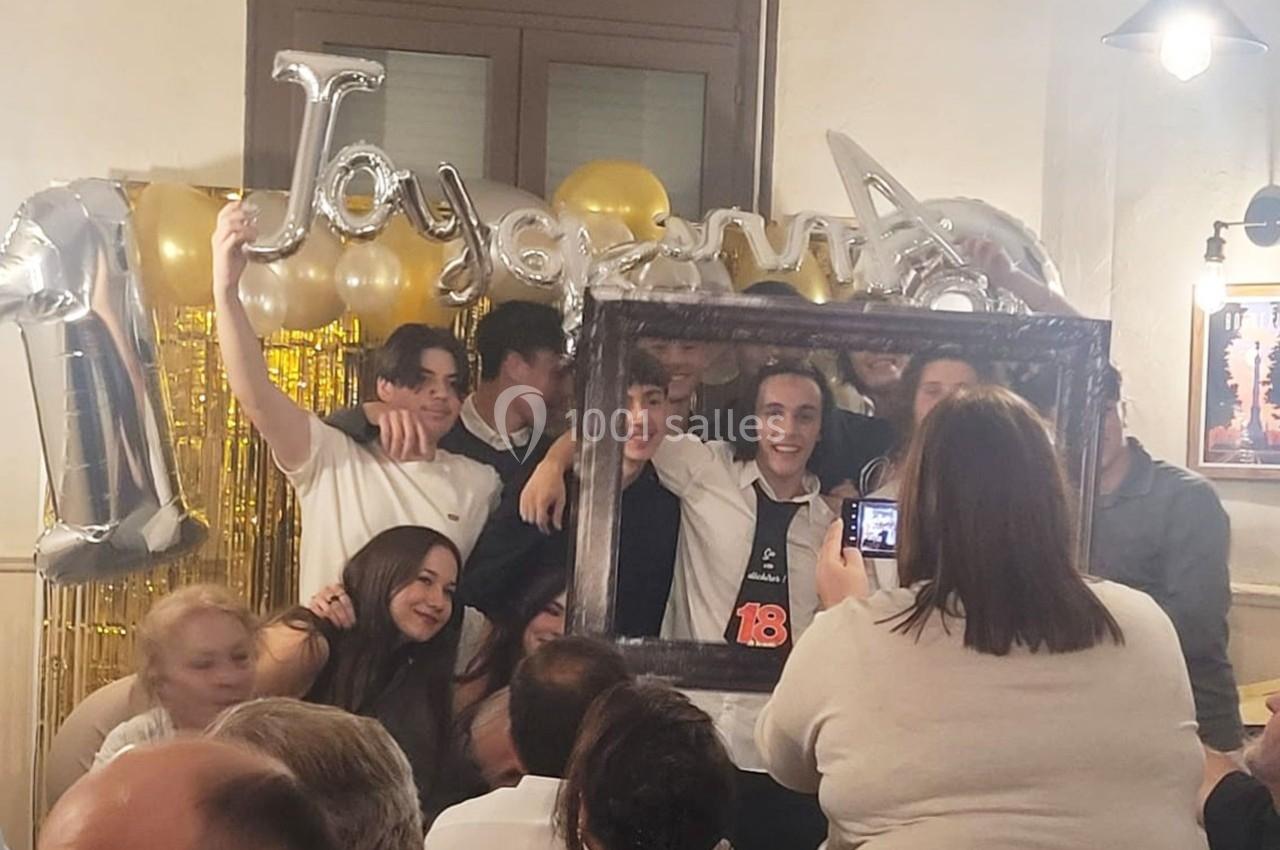 Location salle Bordeaux (Gironde) - Restaurant Le Family #18 Un groupe de jeunes pose avec un cadre photo devant des ballons et une décoration festive lors d'une célébration.